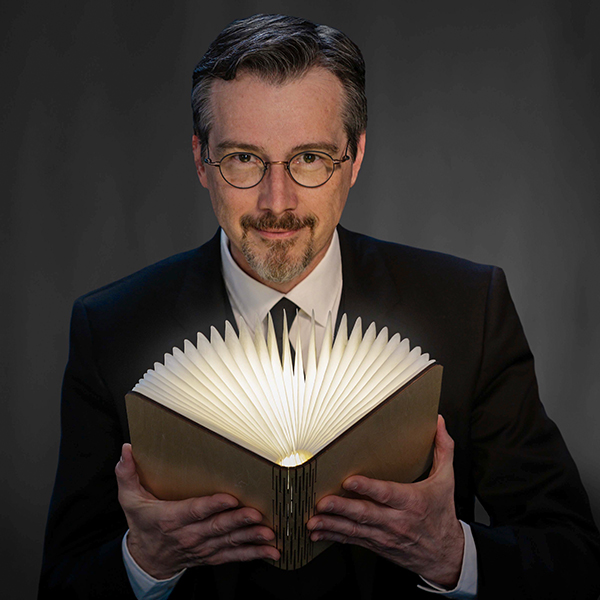 portrait of Dr. Lawrence Hass holding book 