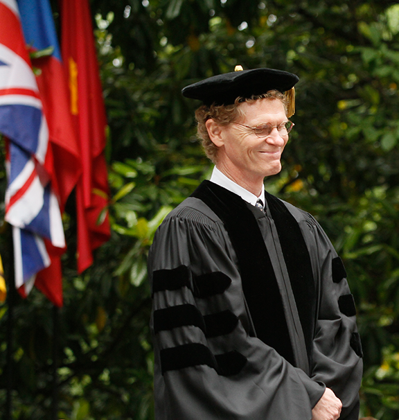 an older man with a cap and gown on smiling proudly