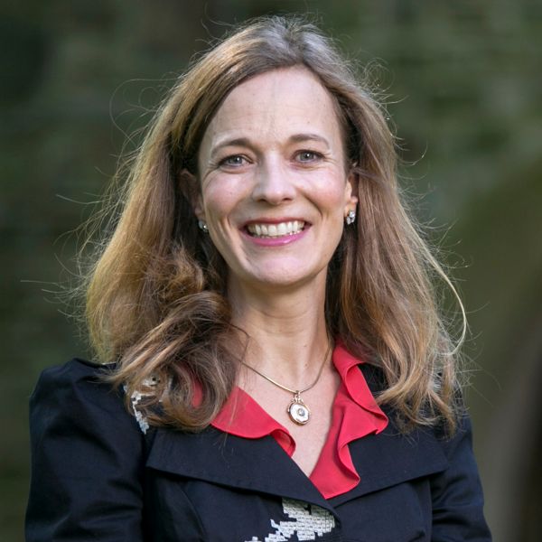 A woman with a red collared shirt smiles at the camera.