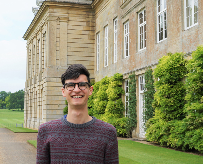 a student smiling in front of a building