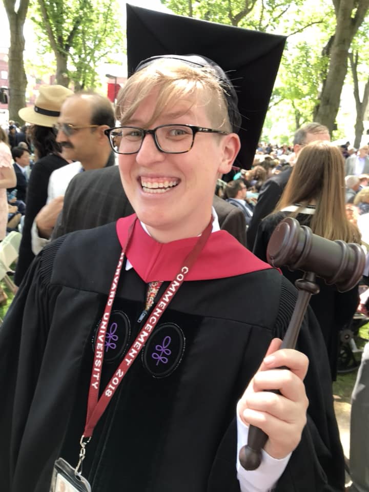 Bacot in cap and gown holding a gavel at Harvard graduation