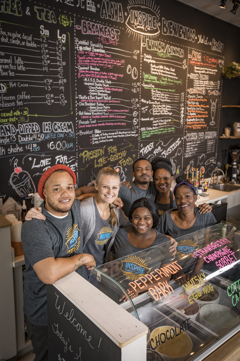 four women and two men behind a food ocunter