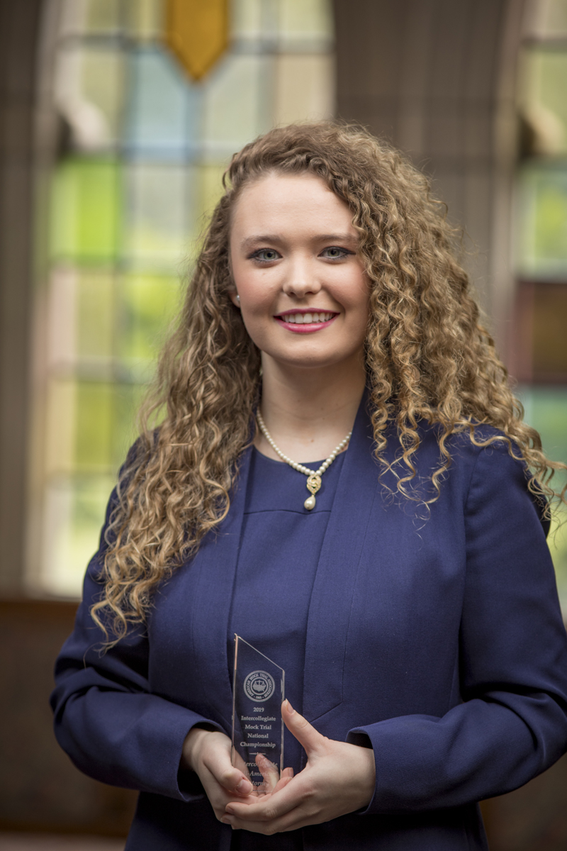 Kelsey McClain holding an award from AMTA