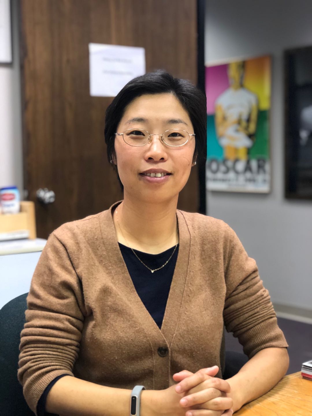 A professor seated at her desk.