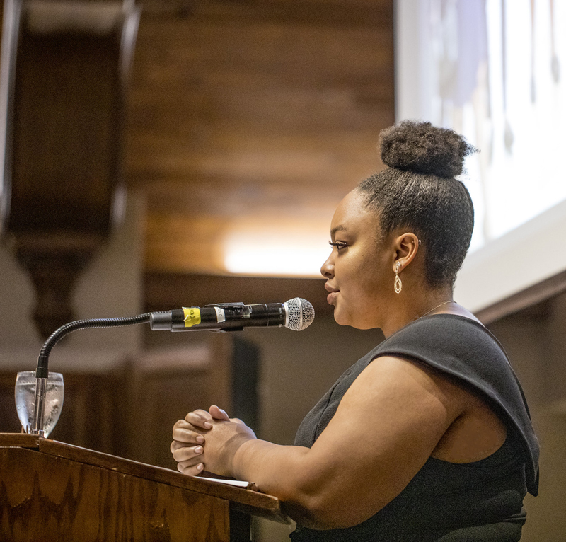 a young African American woman speaks at a lectern