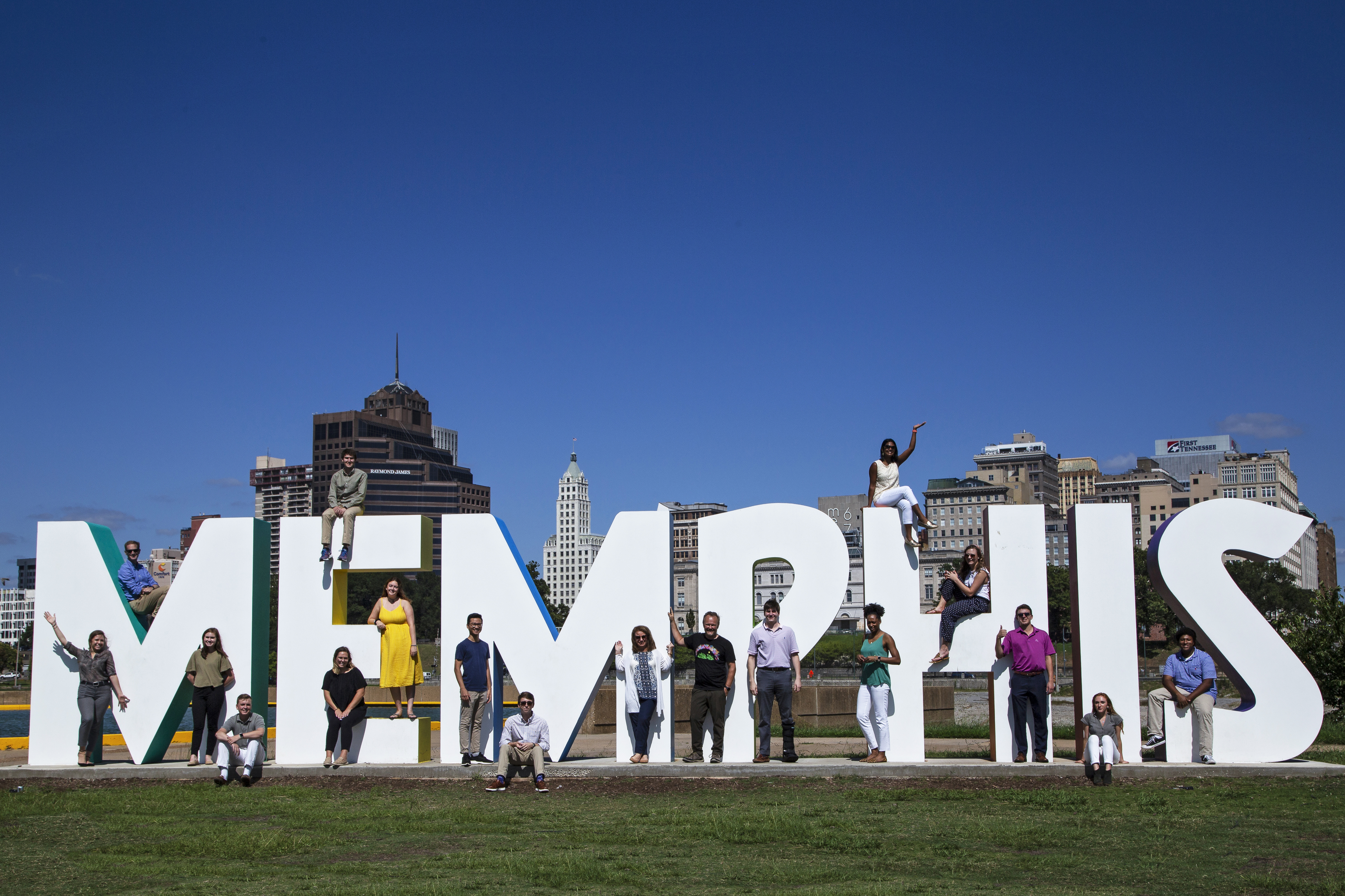People gather in and around a sculpture that spells Memphis