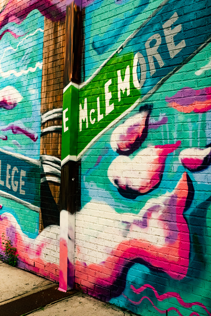 a wall mural featuring a street sign for McLemore street