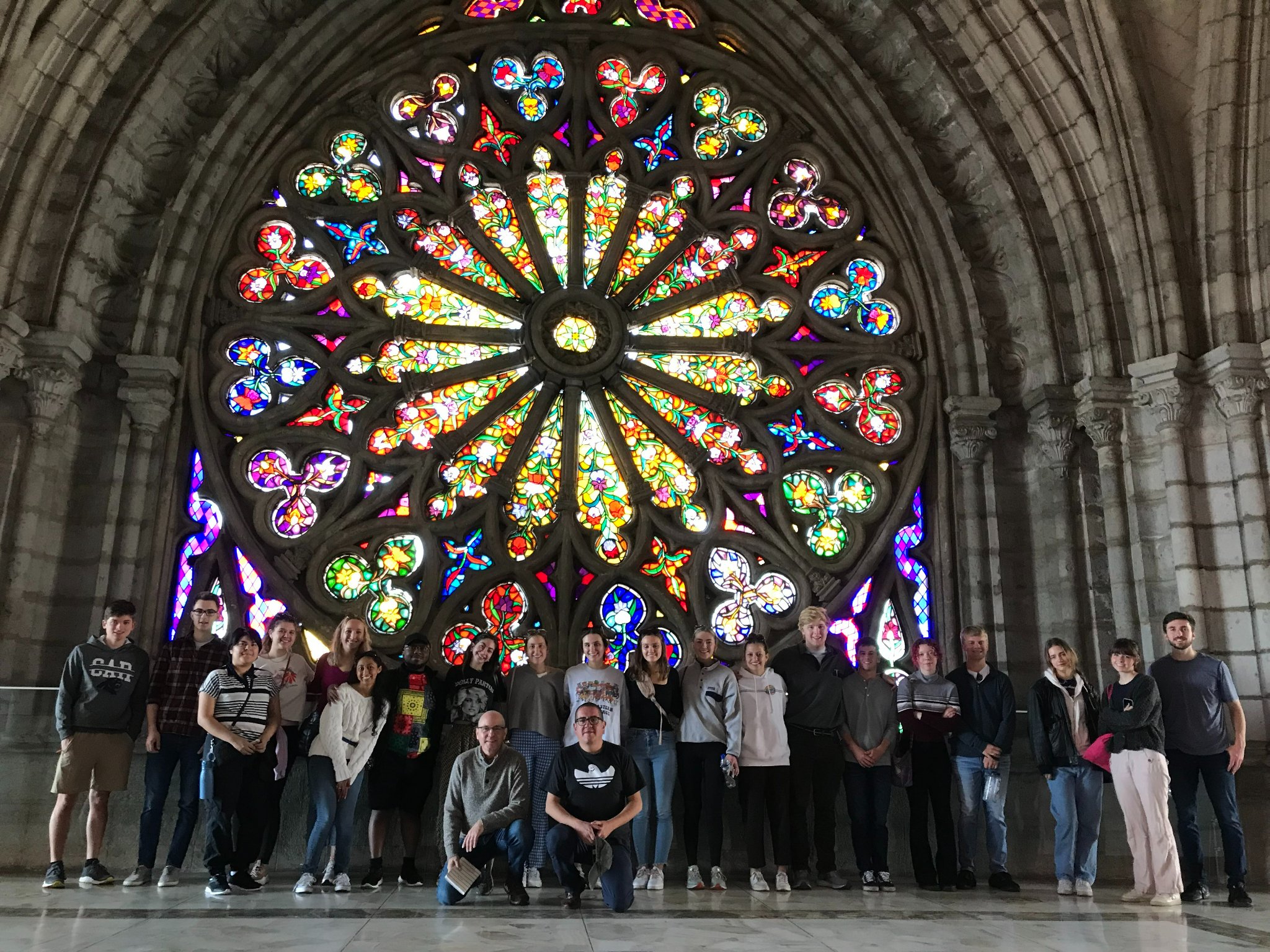 Rhodes College students and faculty standing in front of stained glass window of the Basílica del Voto Nacional