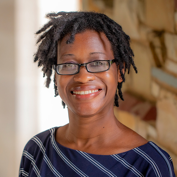 an African American woman in glasses smiles at the camera