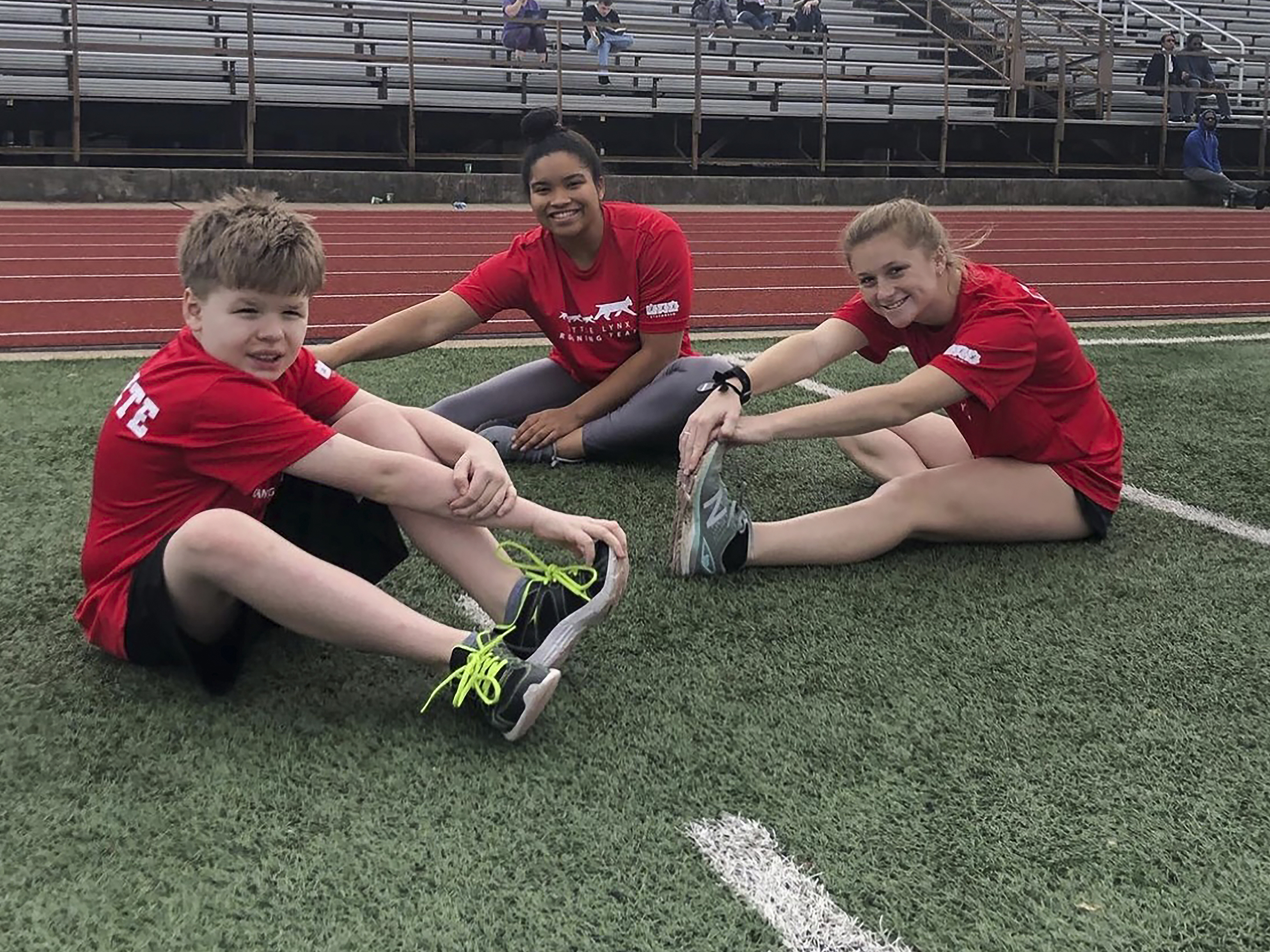 a young boy and college students on a track