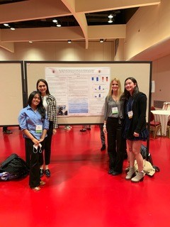 Rhodes College students standing in front of poster at a conference
