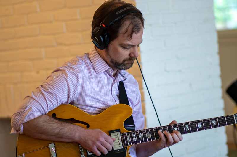 a man in headphones plays the guitar