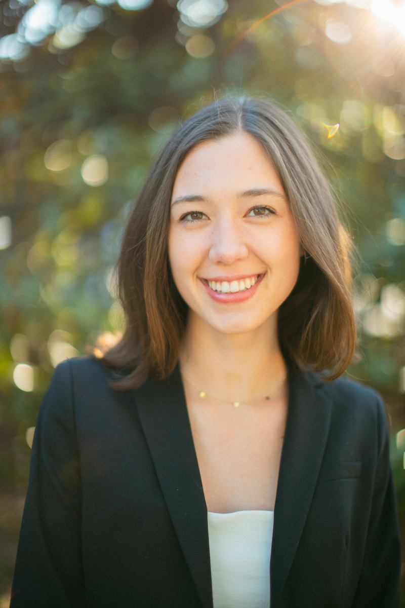 a young woman with brown hair smiles at the camera