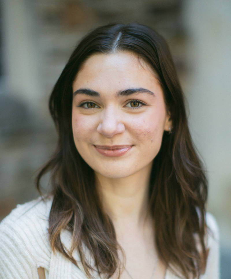 a young woman with long brown hair smiles at the camera