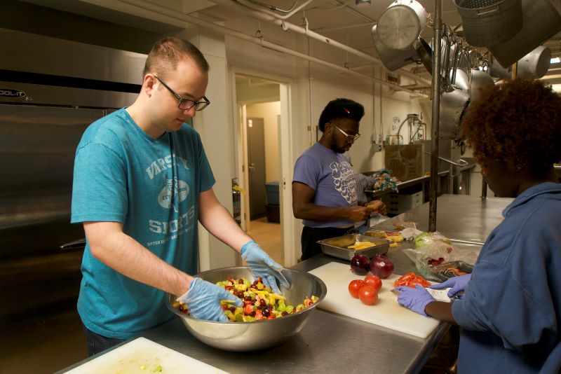 three students prepare food