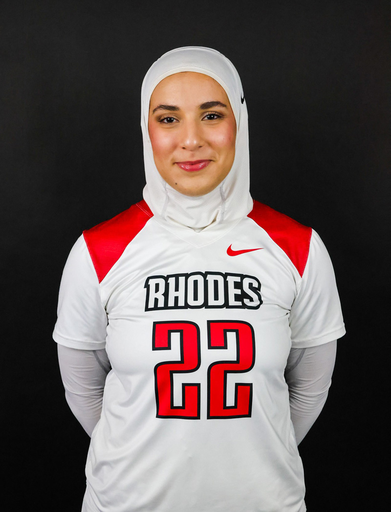 a young woman in a lacrosse uniform wearing a hijab