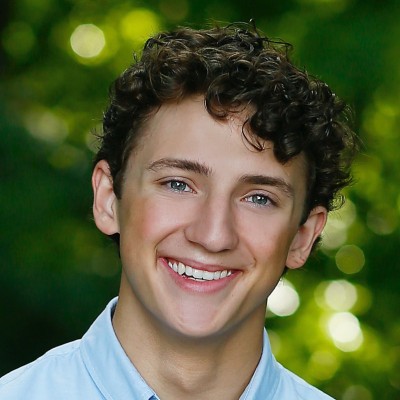 headshot of a young man with curly brown hair