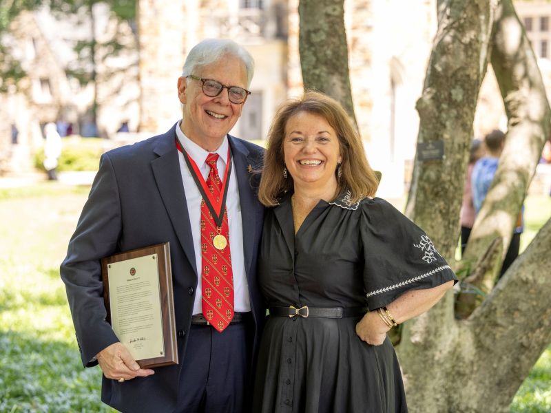 image of Bill Short and Sandi George Tracy standing in front of a campus tree