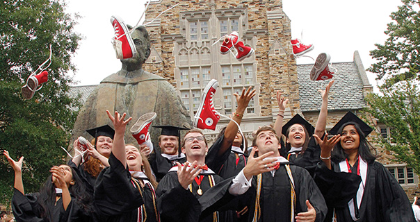 students toss their red sneakers into the air at Commencement