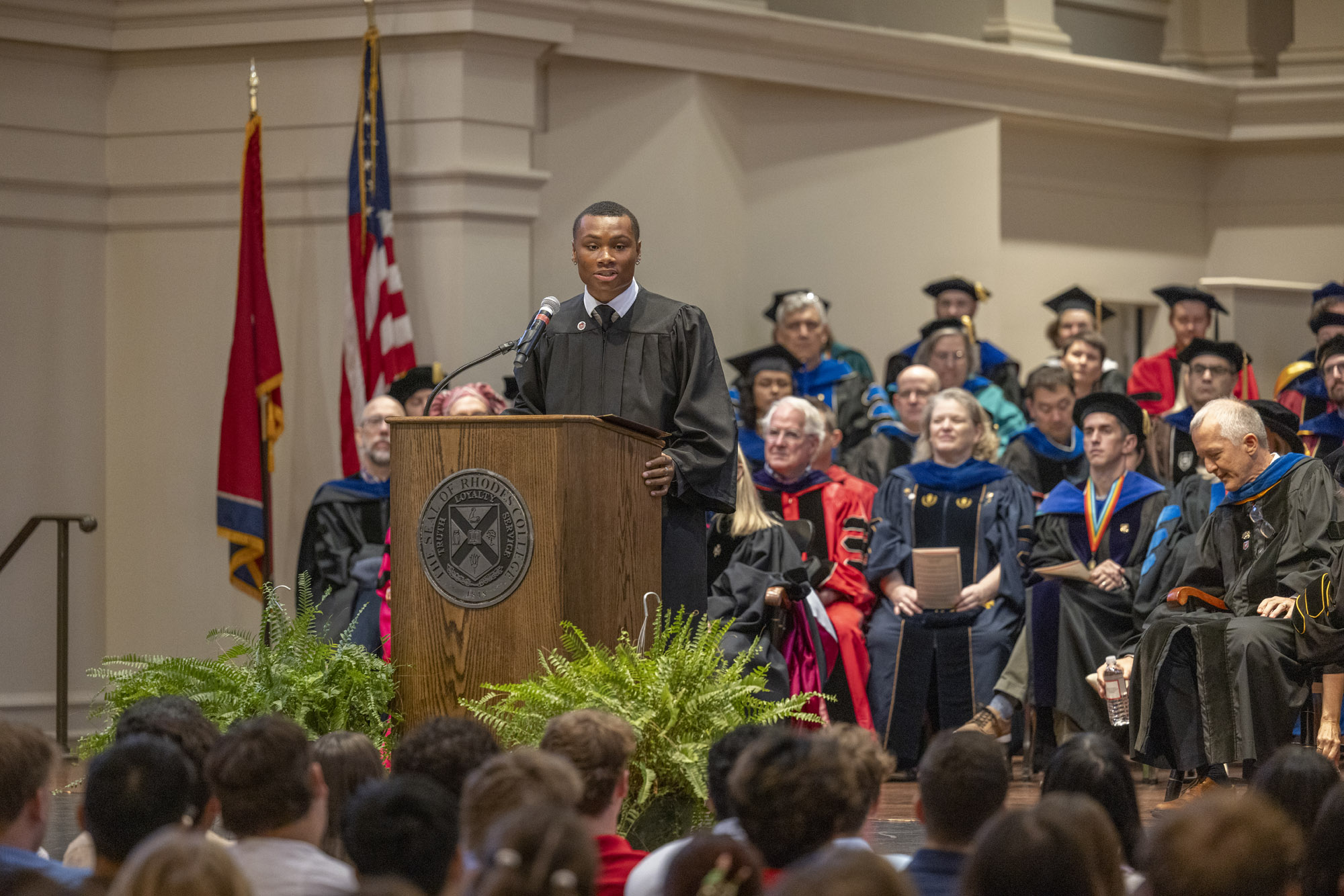 A young Black man speaks at a podium