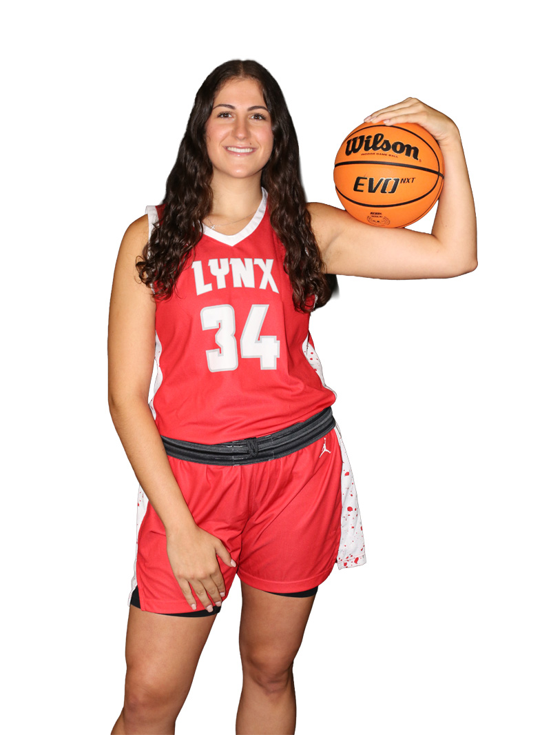 a female student in an athletic uniform holds a basketball