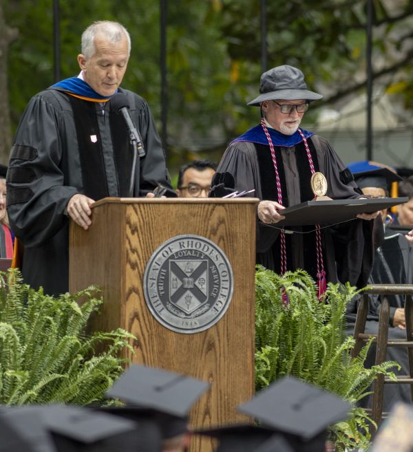 image of Prof. David McCarthy holding plaque on stage