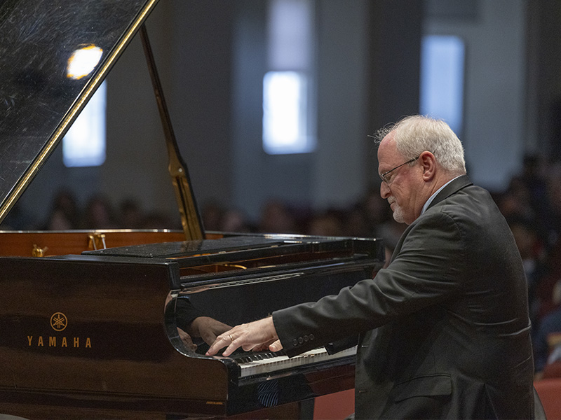 a man plays the piano on a stage
