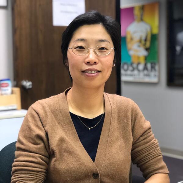 A professor seated at her desk.