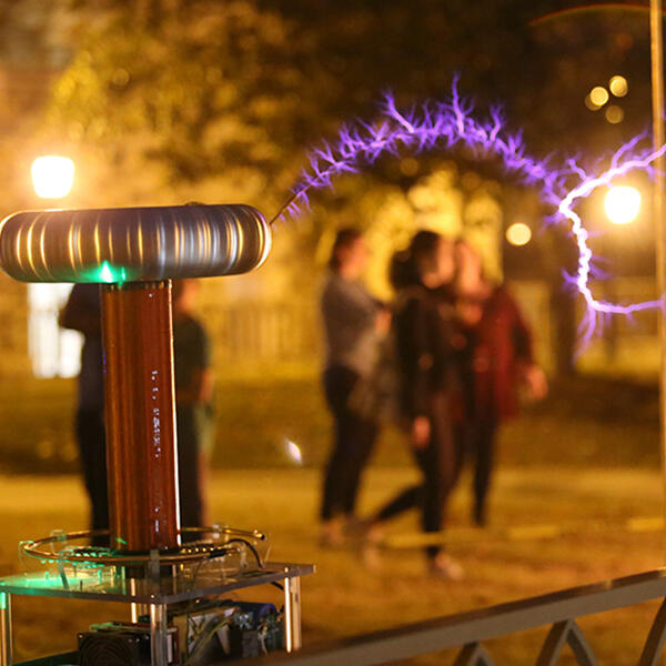 students walk by physics experiments