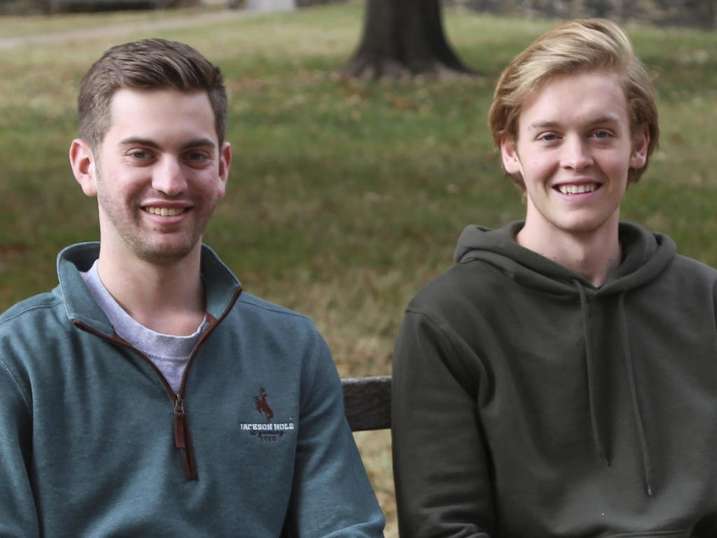 two college students sitting on a bench