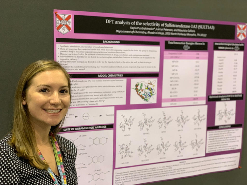 college student standing in front of a science poster
