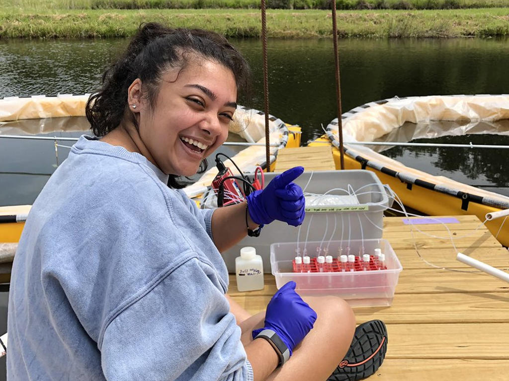 student on a lake with research materials