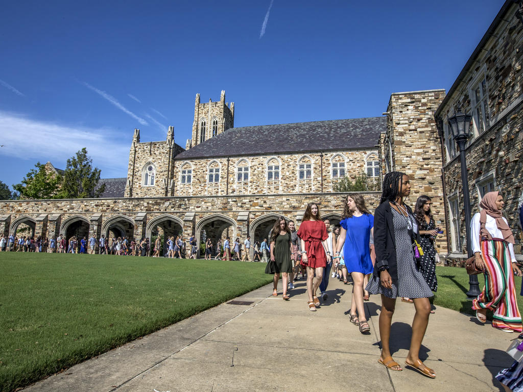 student processional going past a Gothic stone library