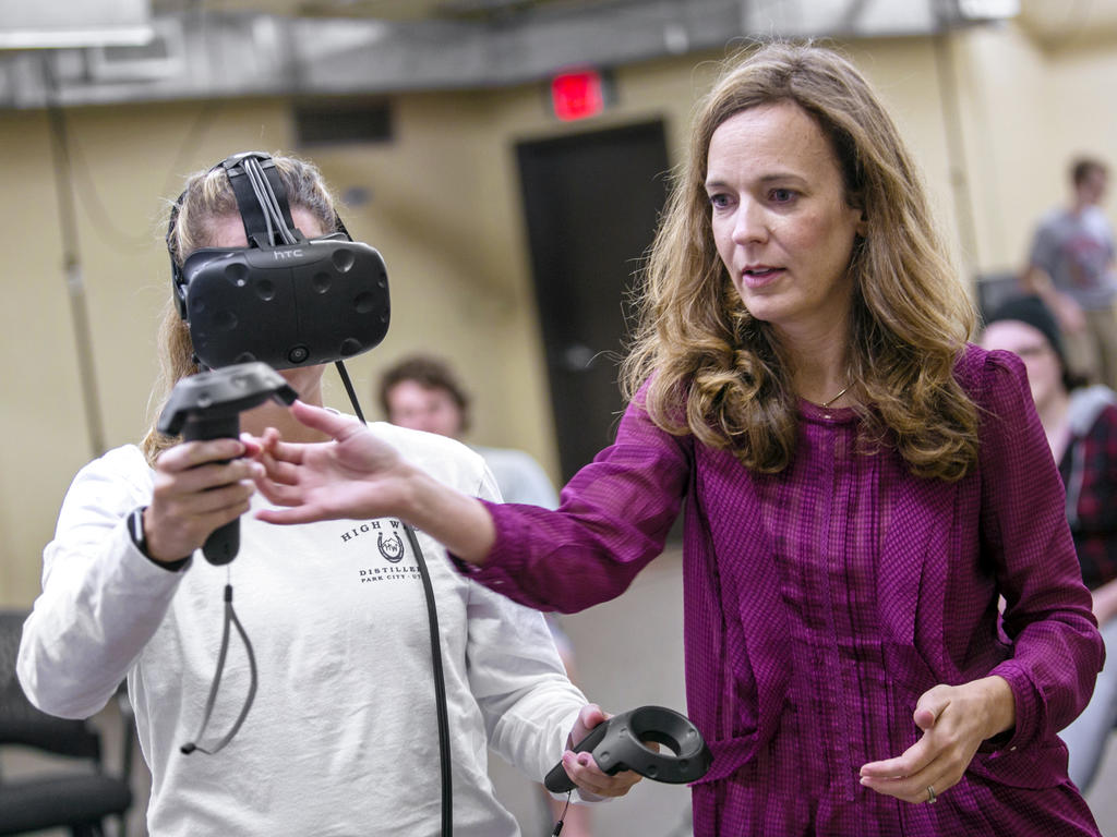 Professor directs student wearing virtual reality gear