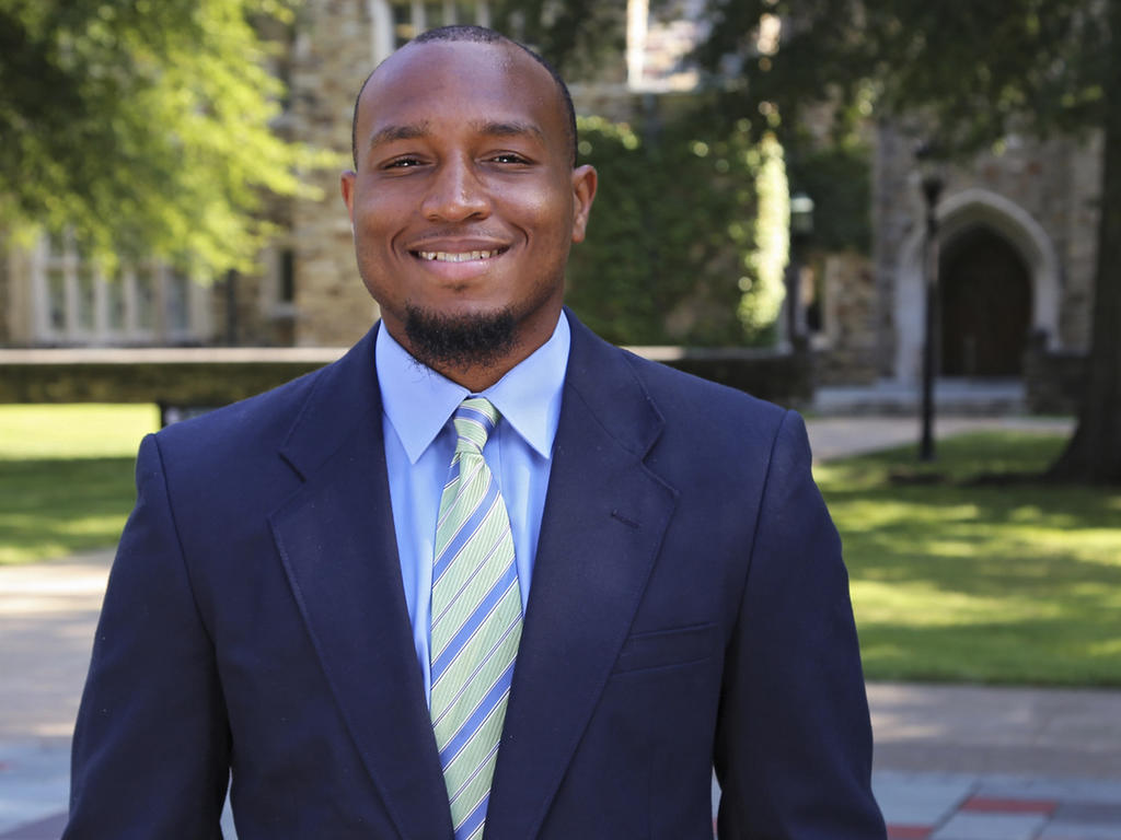 a yoiung African American man in a blue suit and tie