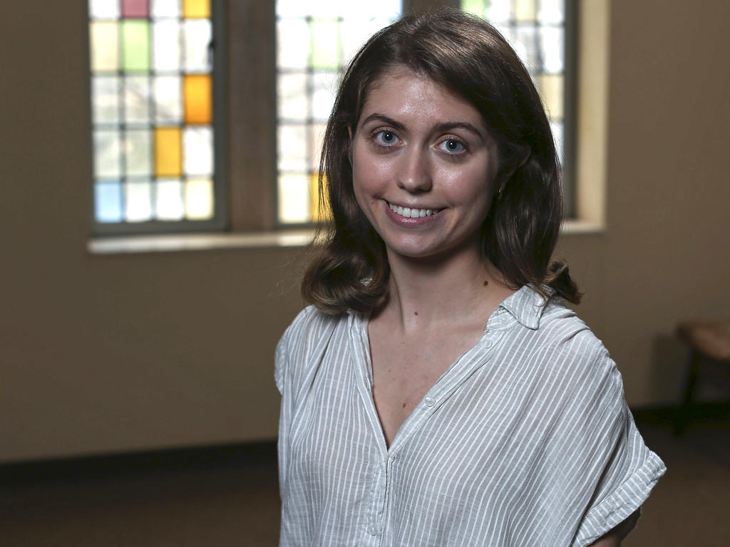 a young woman with shoulder length brown hair smiles at the camera