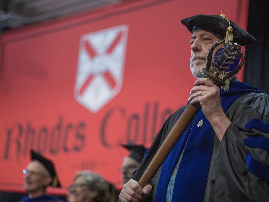 Person in academic regalia holding a mace