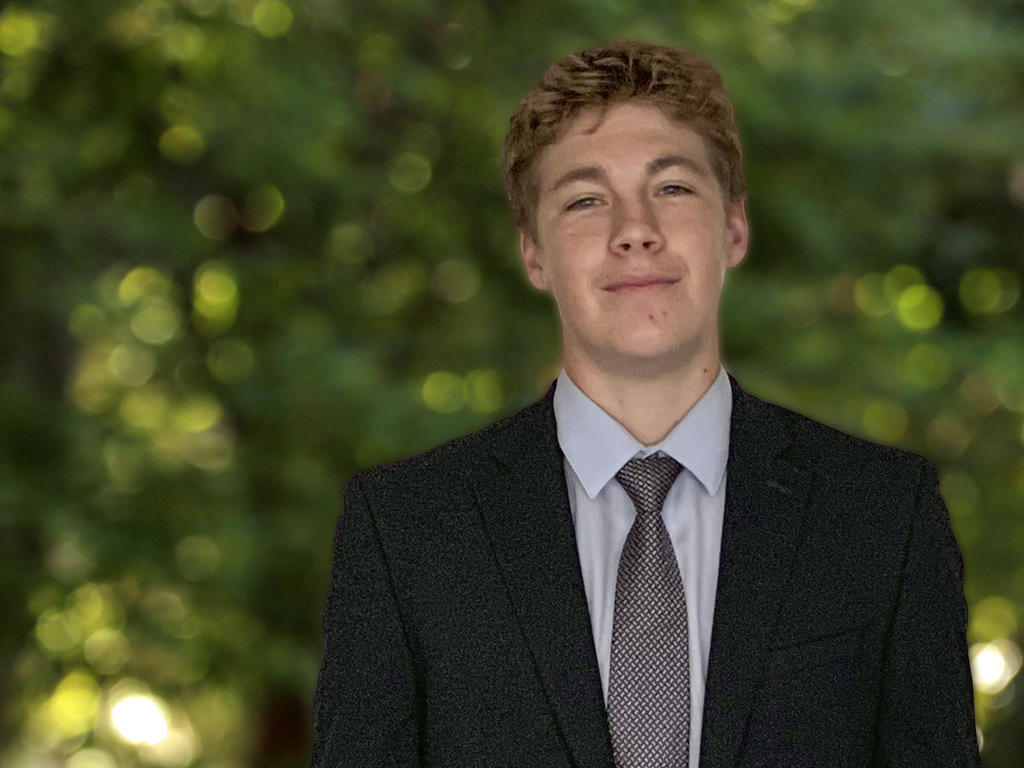 a young man in a suit smiles at the camera