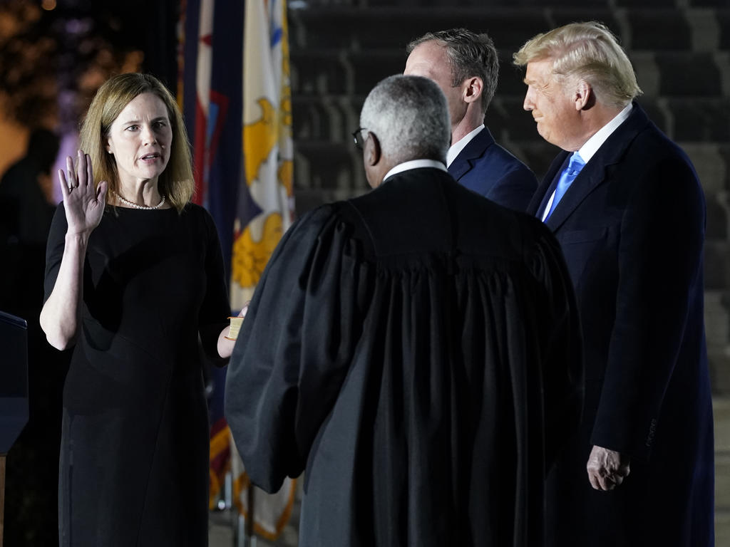 woman holds up hand while men look on