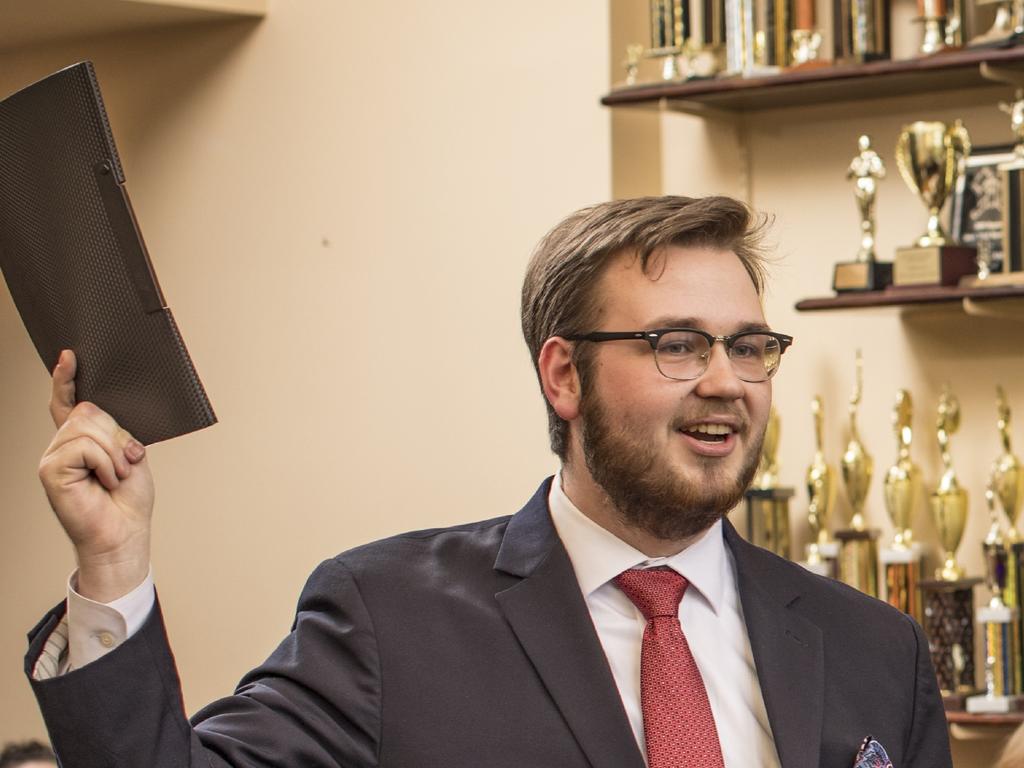 a young man in a suit holding a legal file