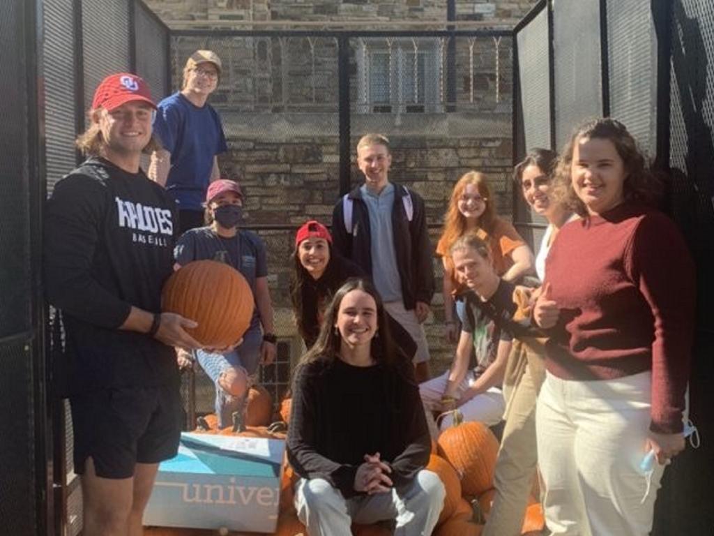 Rhodes College students holding pumpkins