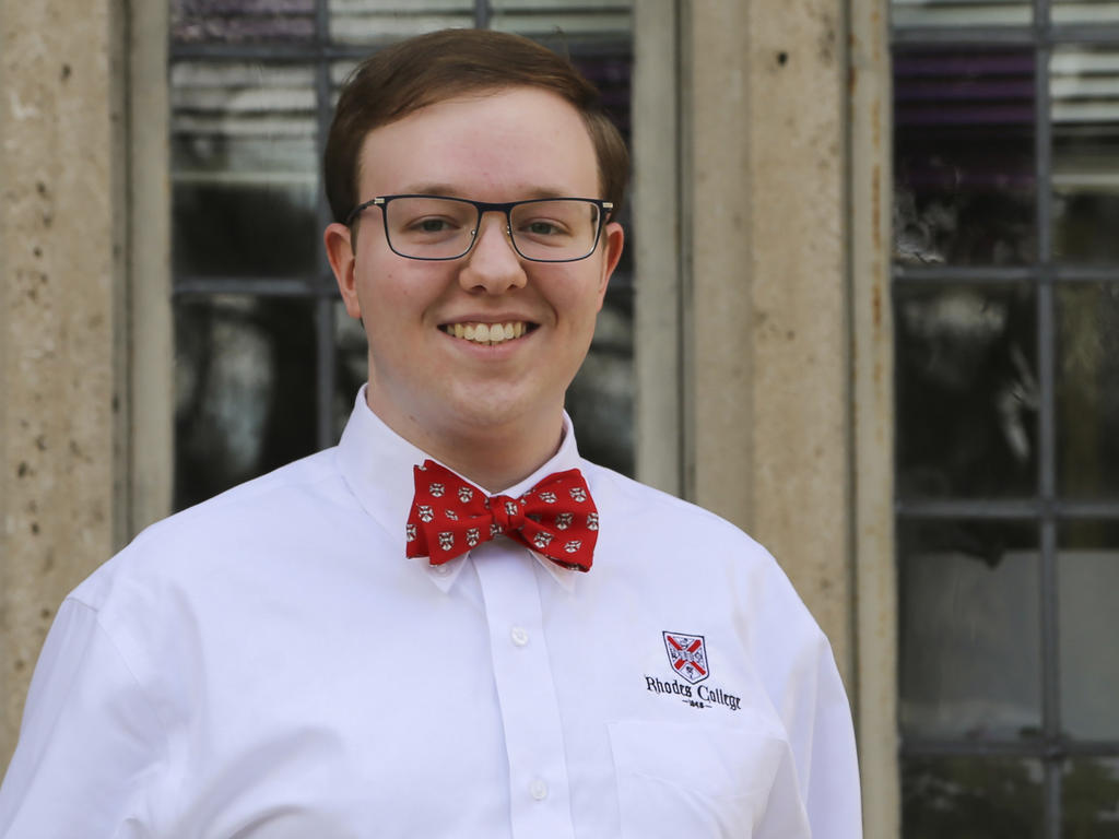 a young man wearing glasses and a red bowtie