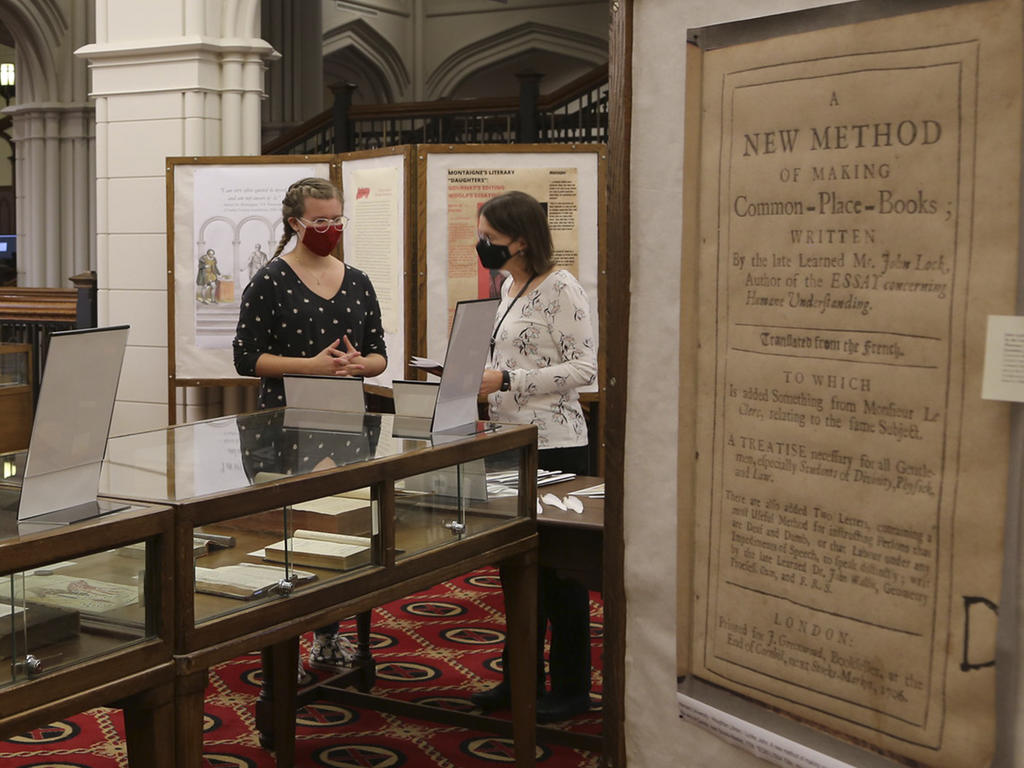 two people talk in front of a display case