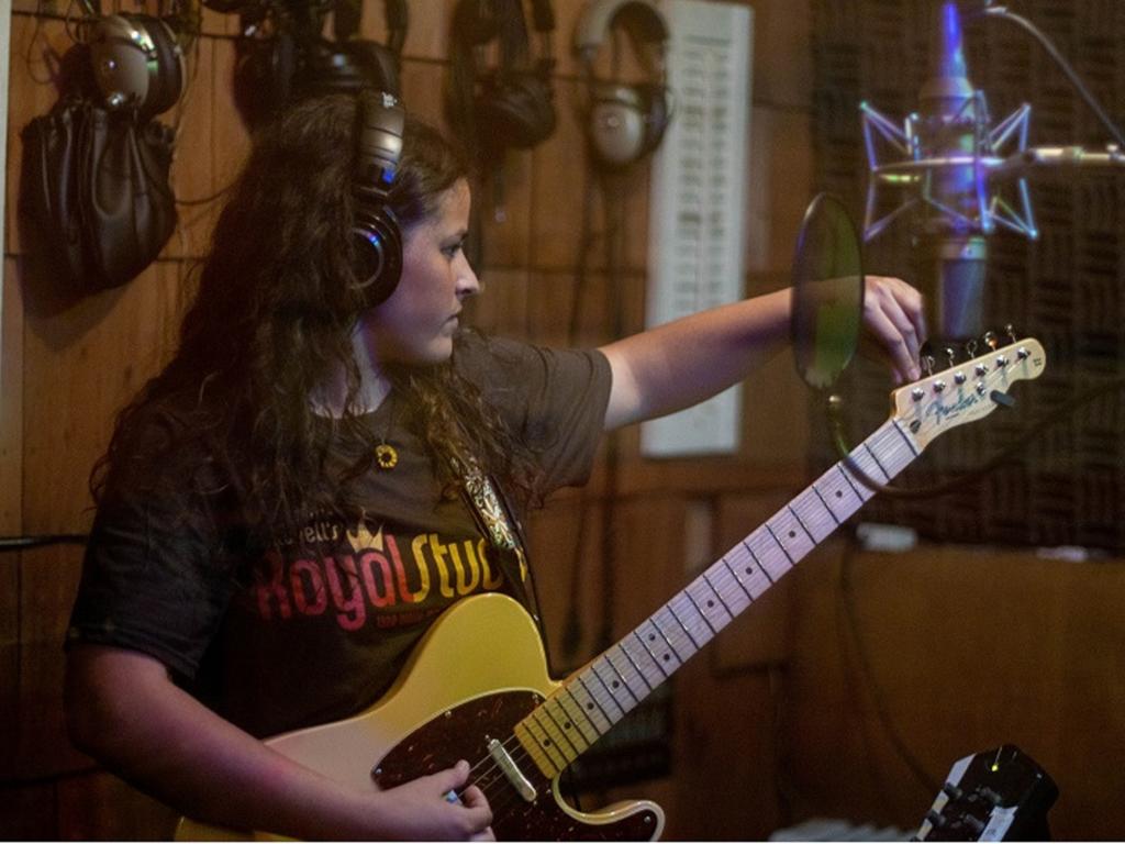 Rhodes College student Lina Beach playing the guitar