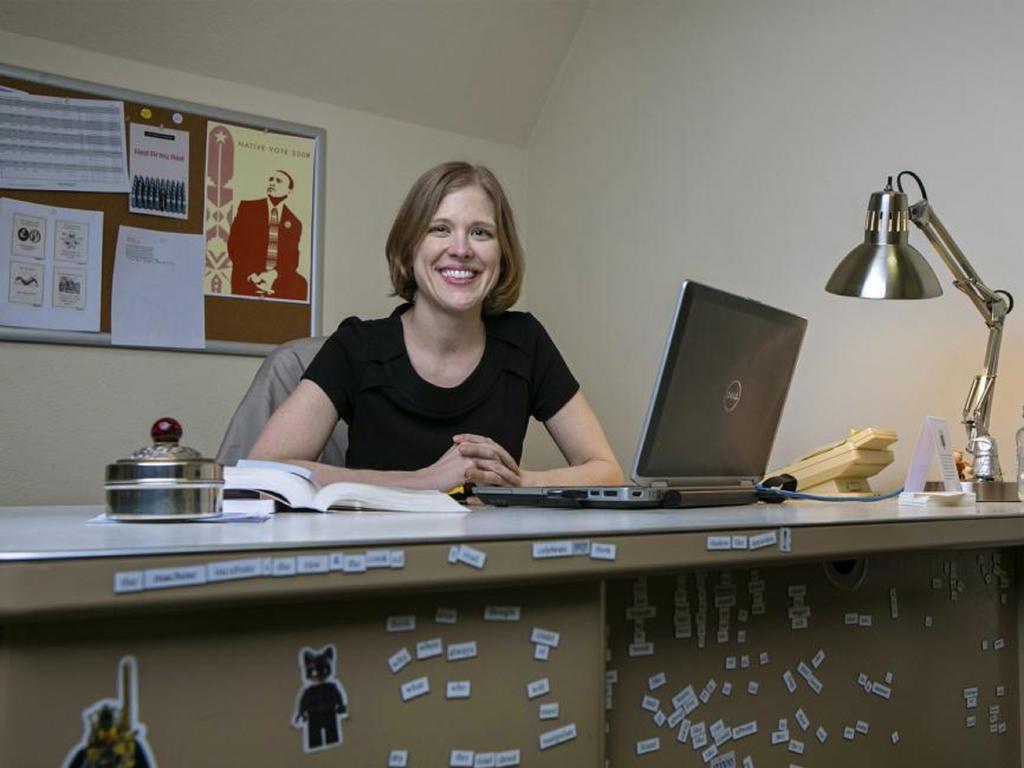 image of Rhodes College professor Caki Wilkinson sitting at a desk