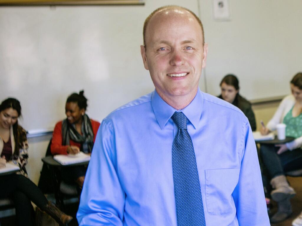 Rhodes College professor Eric Henager standing in front of a class of students 