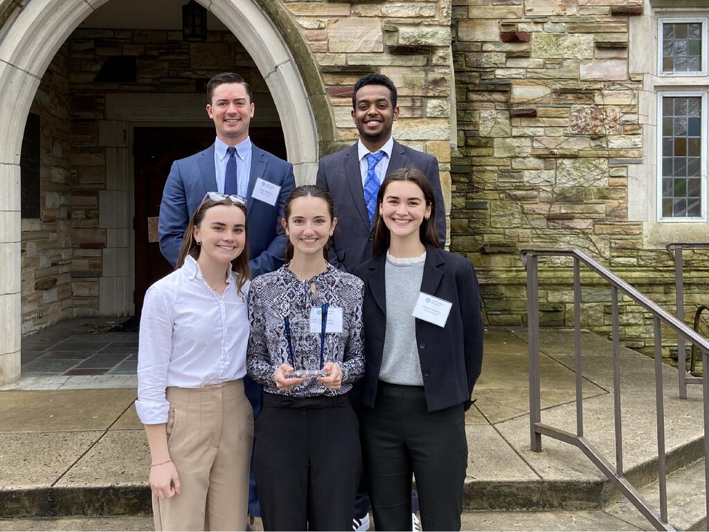 group image of Rhodes College students standing in front of a campus building