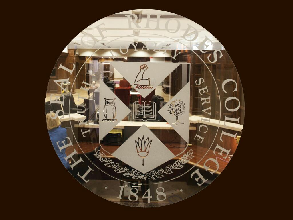image of glass Rhodes College seal on door