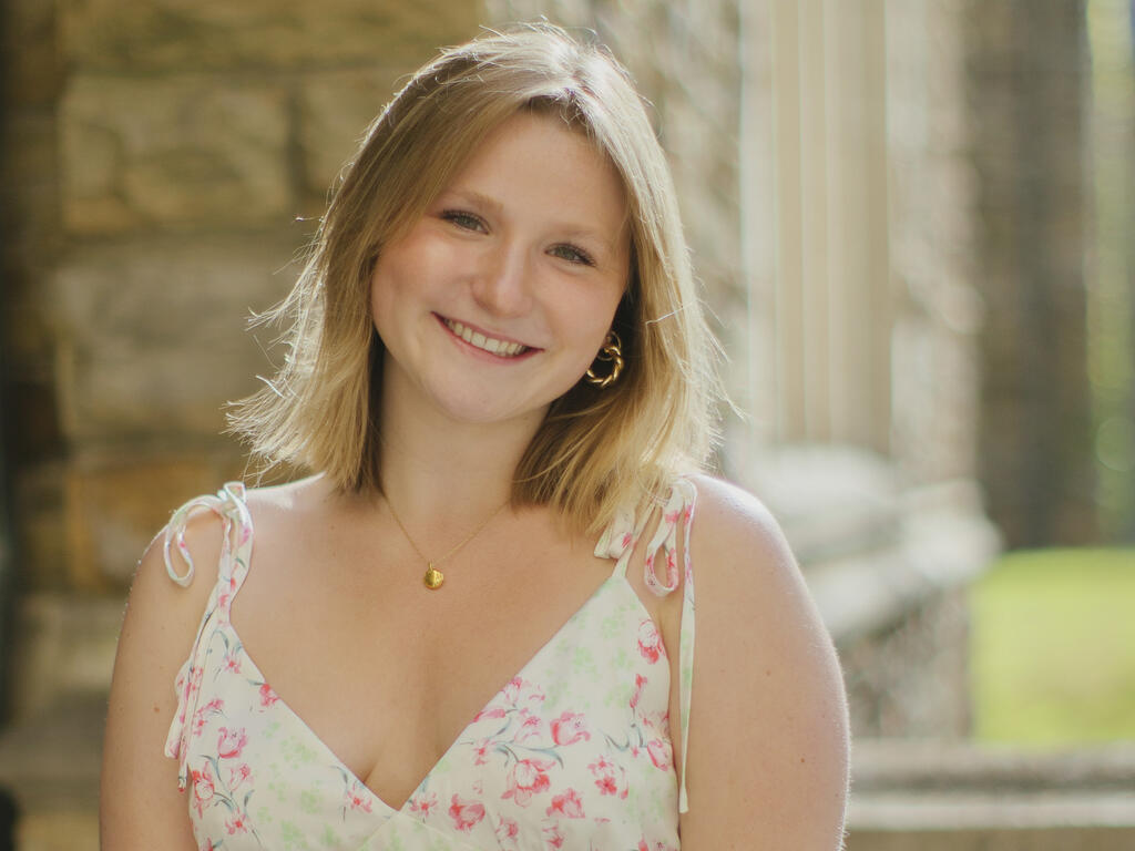 a young woman with blonde hair smiles at the camera