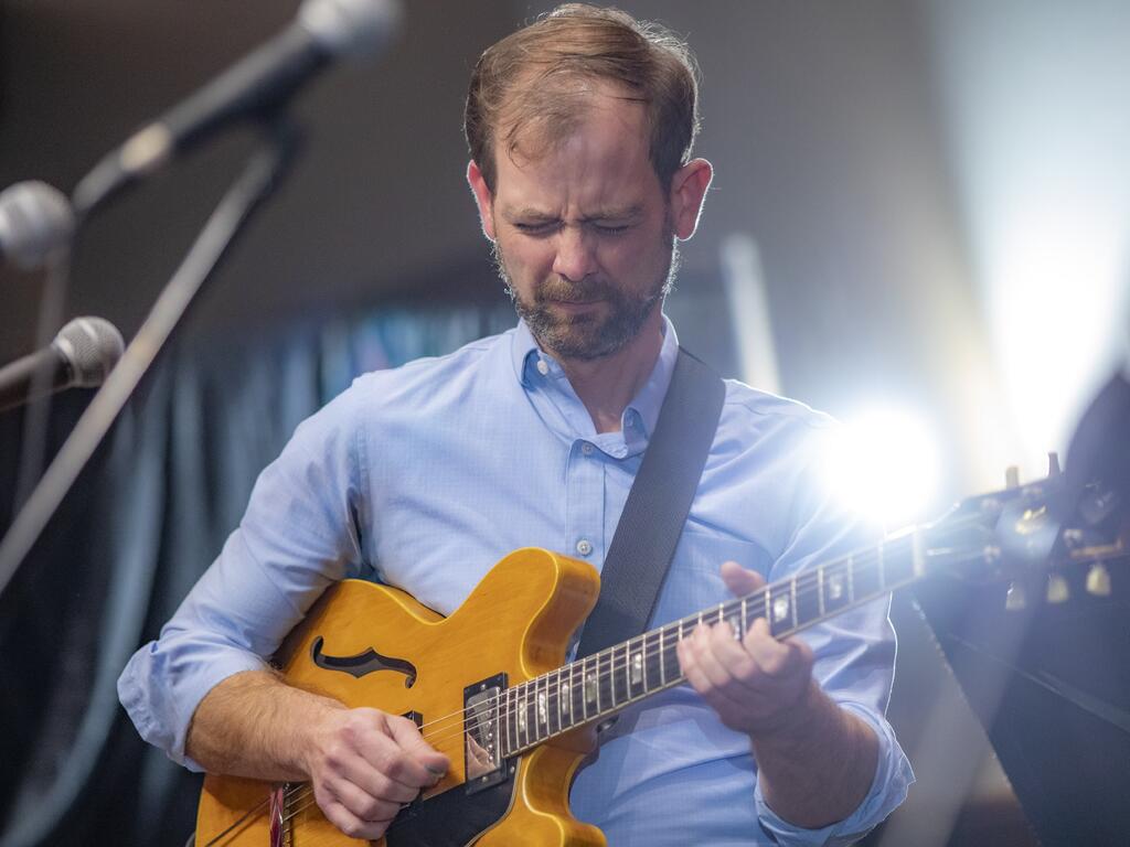 image of John Bass playing the guitar